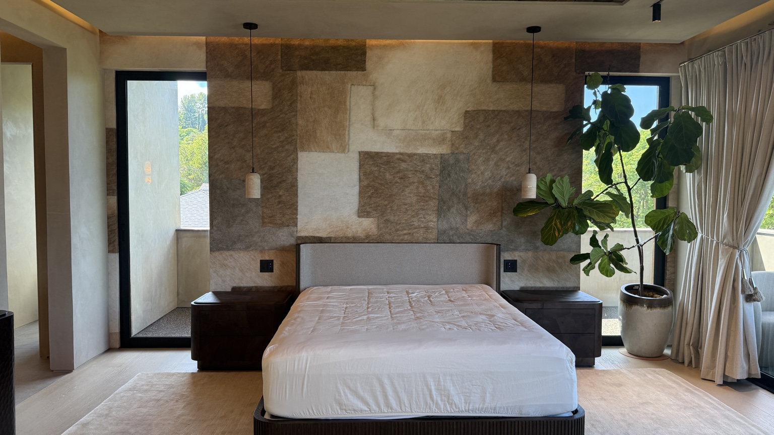 Natural-toned artistic wallcovering installed behind a bed