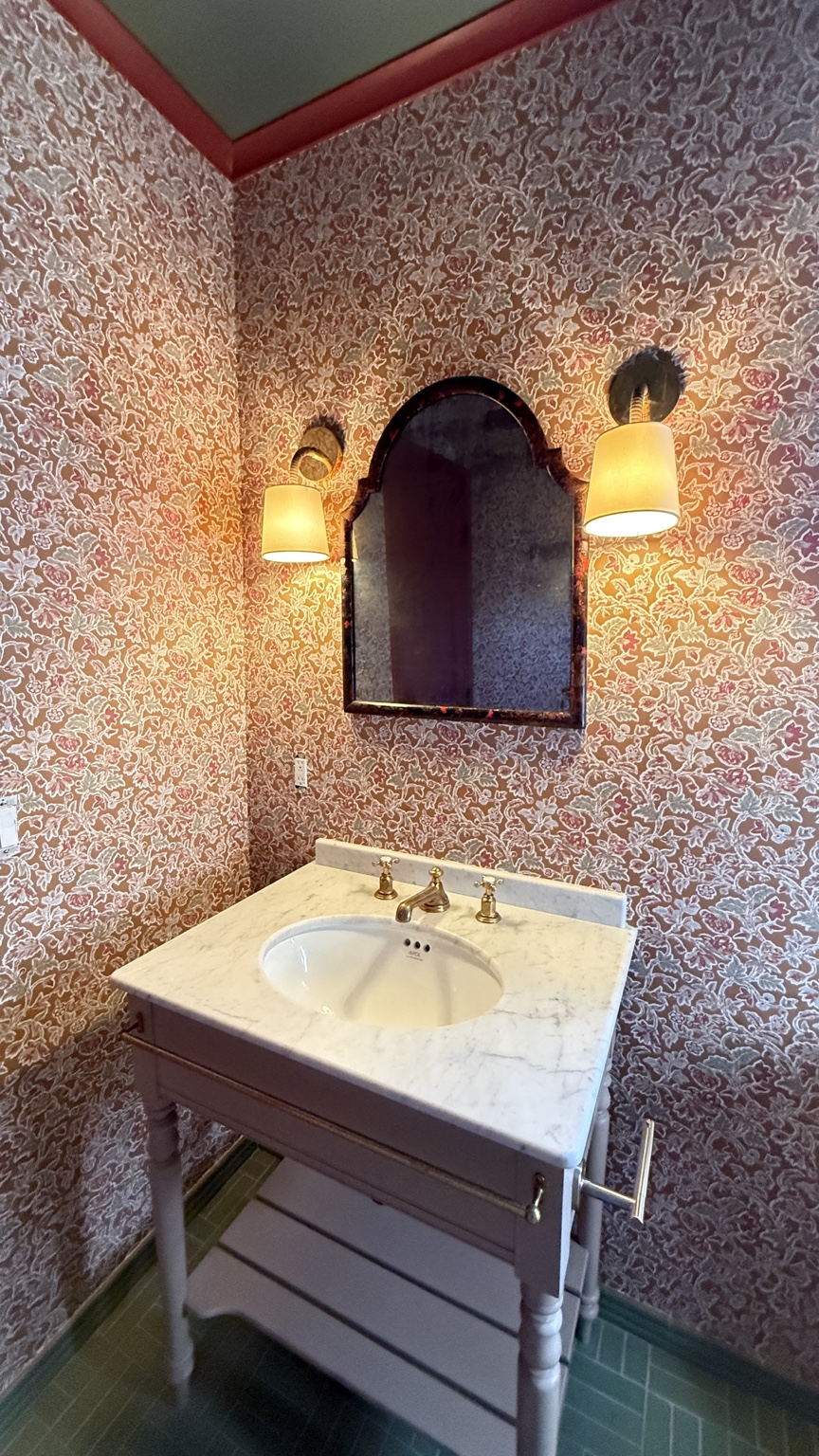 Detailed red floral wallpaper installation in a powder room